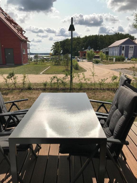 a table and chairs on a deck with a view of a field at Hafendorf Haus 5_ Apartment 3 in Plau am See