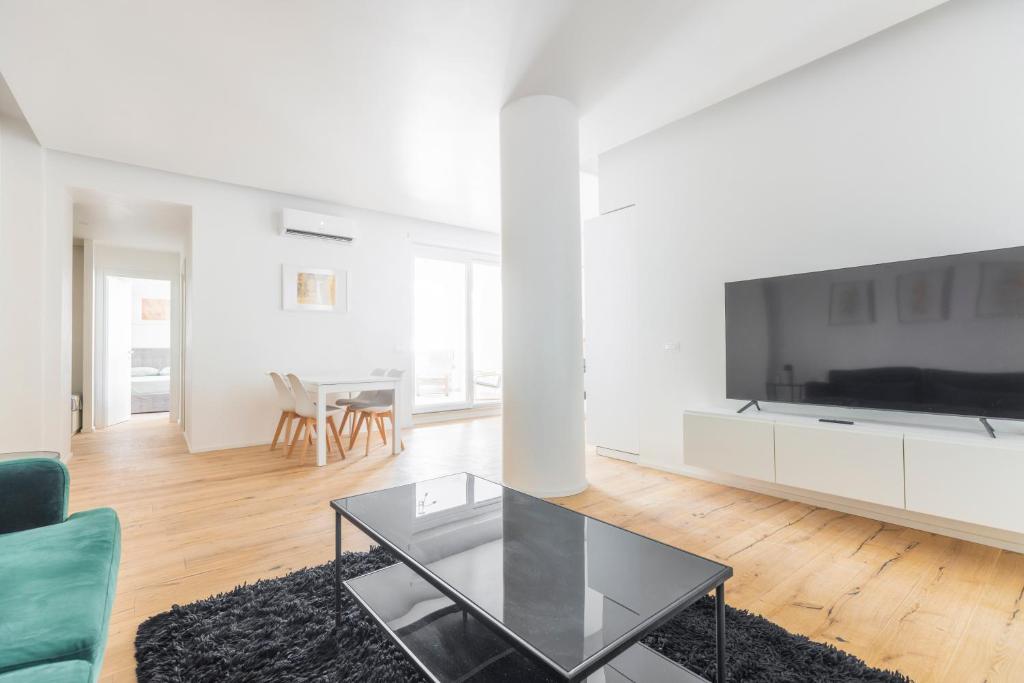a living room with a large tv and a glass table at La Dolce Vita - Luxury Stylish Flats in Trastevere 70-90sqm in Rome