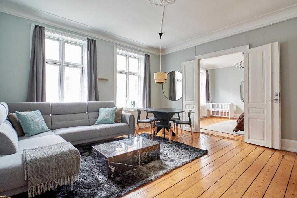 a living room with a couch and a table at Spacious Scandinavian 3BR Flat in Vibrant Area in Copenhagen