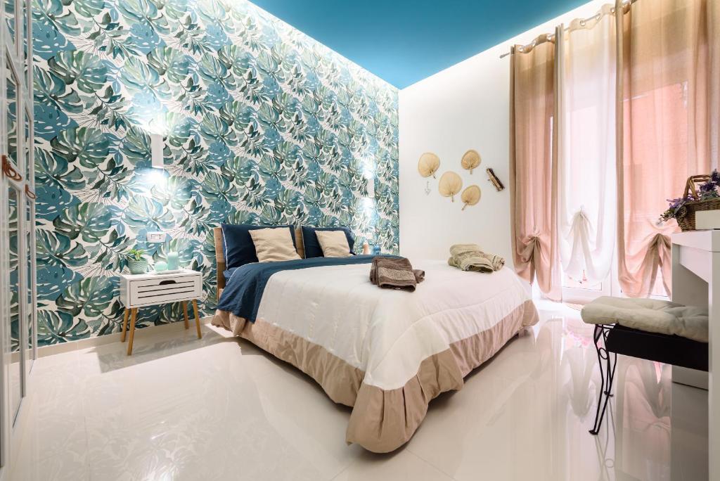 een slaapkamer met een bed en een blauwe en witte muur bij Fermata Duomo in Napels