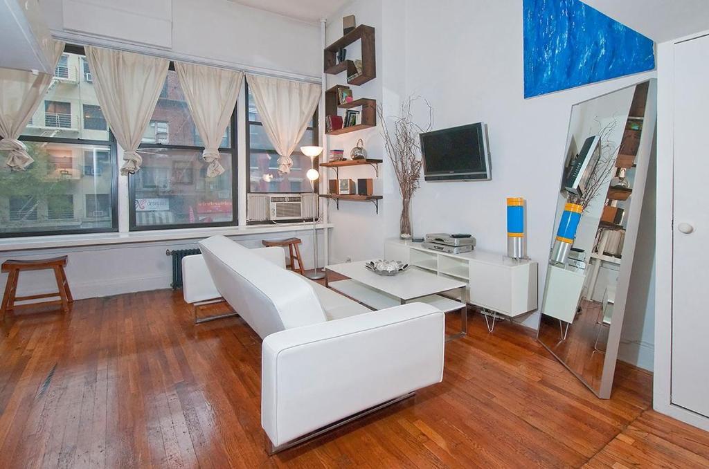 sala de estar con sofá blanco y mesa en Park Ave Apartments Midtown Next to Times Square, en Nueva York