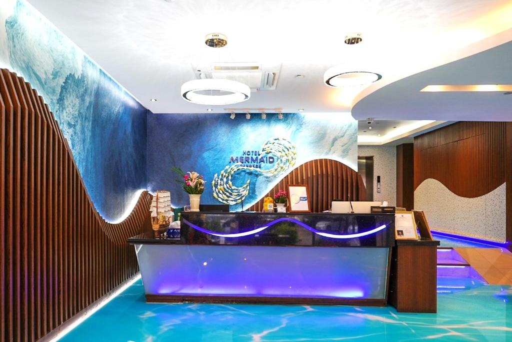 a lobby of a hotel with a wave painted on the wall at Hotel Mermaid Bangkok in Bangkok