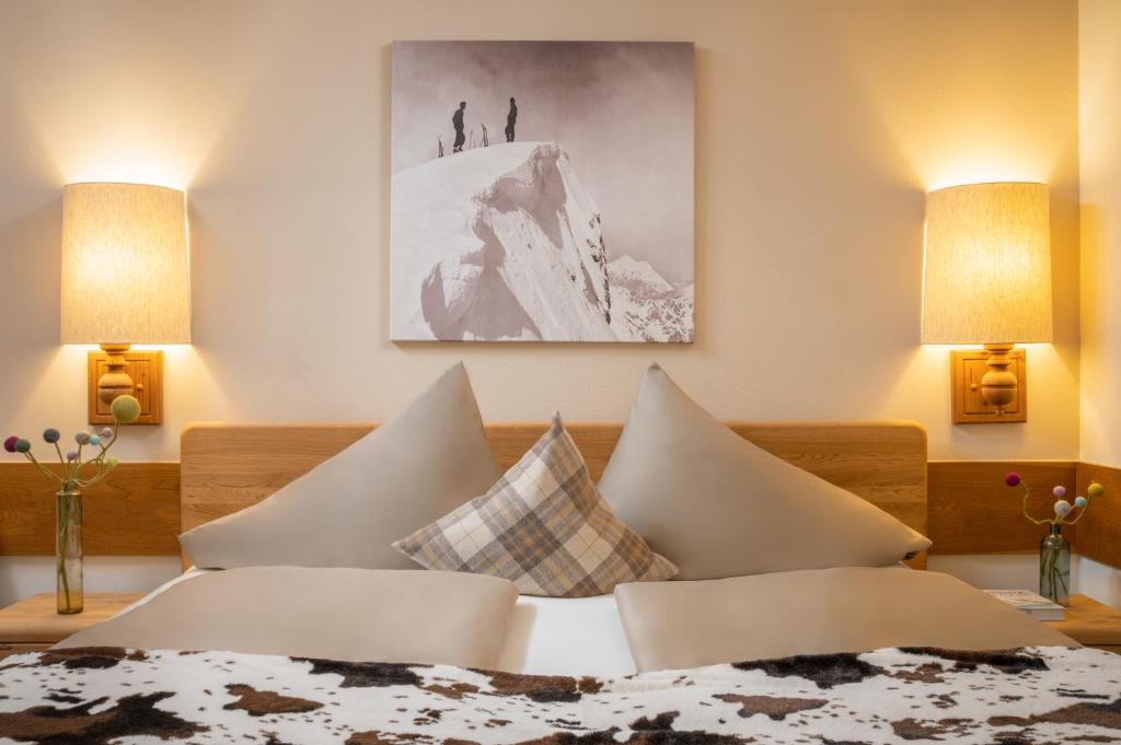 a bedroom with a bed with pillows on it at Hotel-Pension Schattberg in Saalbach Hinterglemm