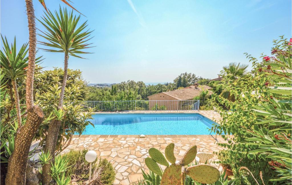 uma piscina num quintal com palmeiras em Beautiful Home In La Gaude With Kitchen em La Gaude