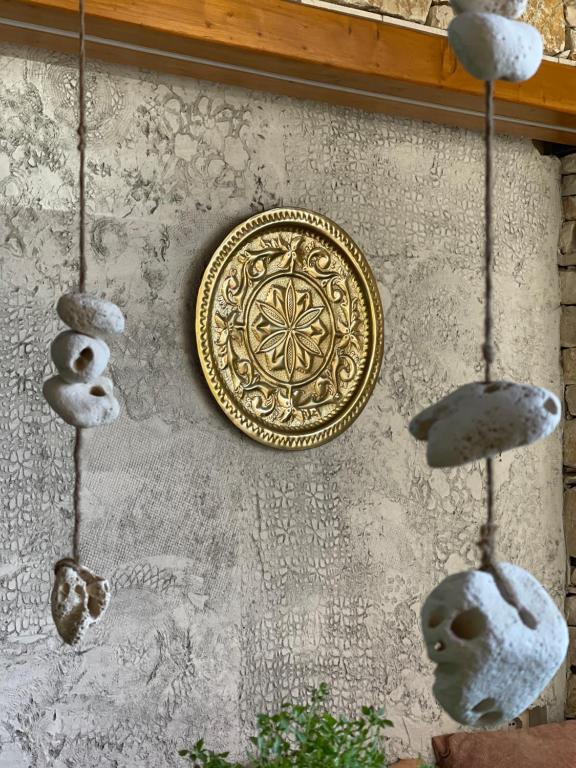 a wall with a gold plate and some rocks at Vila Arial in Vlorë