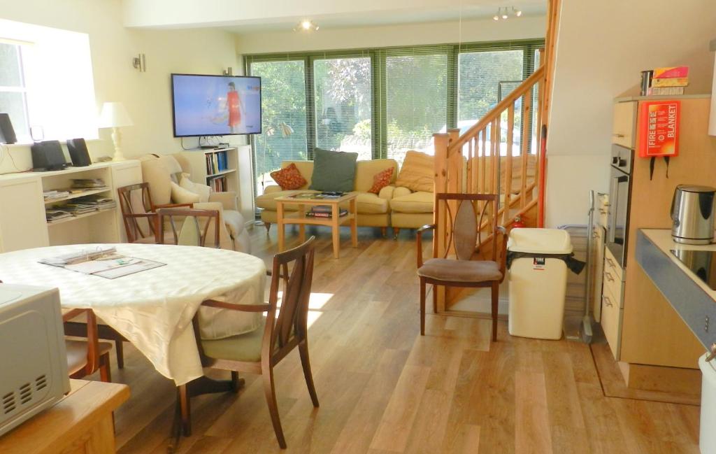 cocina y sala de estar con mesa y sillas en Cotswold Charm George Barn en Chipping Campden