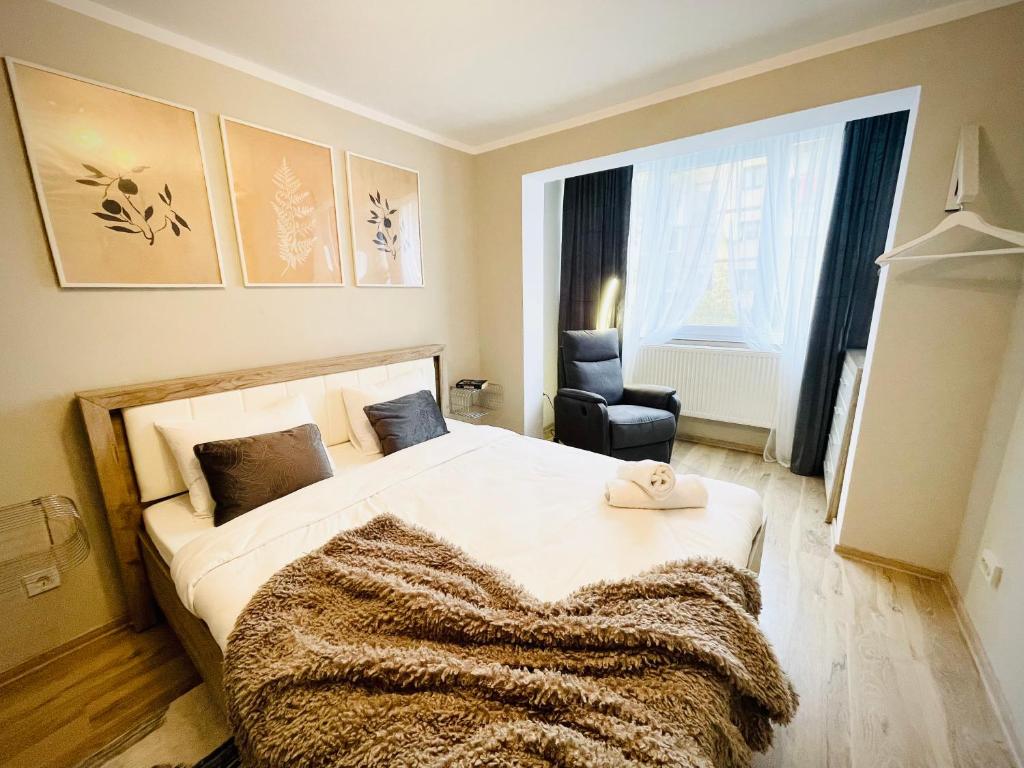 een slaapkamer met een groot bed met een deken erop bij Hygge place to stay - self check in nonstop 24h-wifi in Reşiţa