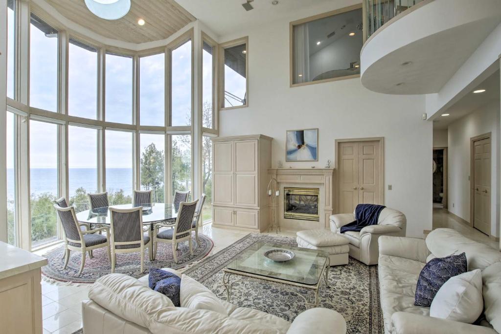 a living room with white furniture and a fireplace at Grand Egg Harbor Home with Stunning Lake Views! in Egg Harbor