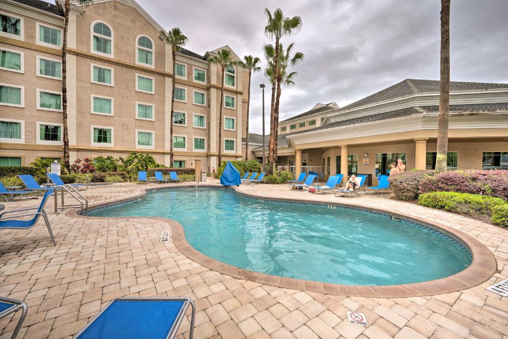 a swimming pool at a hotel with chairs and a building at Orlando Family Condo about 9 Mi to Magic Kingdom! in Orlando