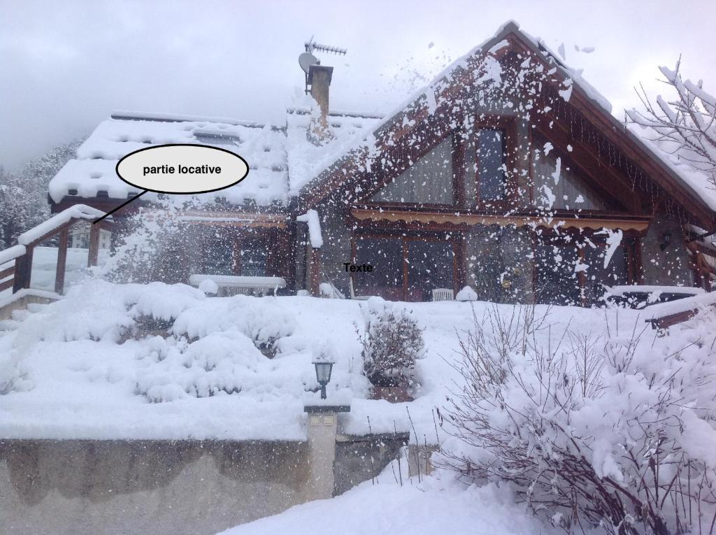 une maison recouverte de neige avec les mots "guérir la prairie" dans l'établissement Partie de chalet, à Saint-Chaffrey