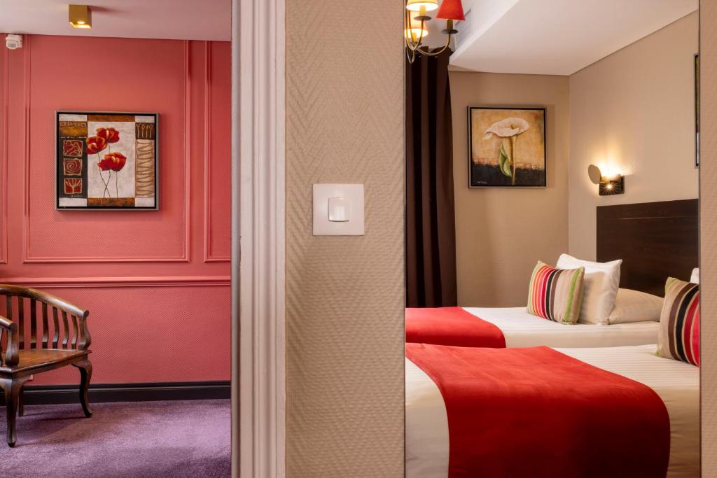 two beds in a hotel room with red walls at Chatillon Paris Montparnasse in Paris