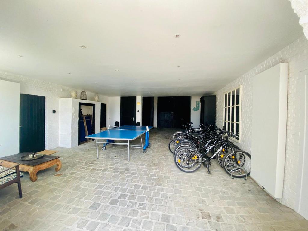 a room with a ping pong table and a group of bikes at Little Farm Comfort&amp;PrestigeHouse in Ittre