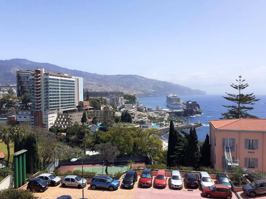 a group of cars parked in a parking lot near the ocean at One bedroom apartement with sea view shared pool and enclosed garden at Sao Martinho Funchal in Funchal