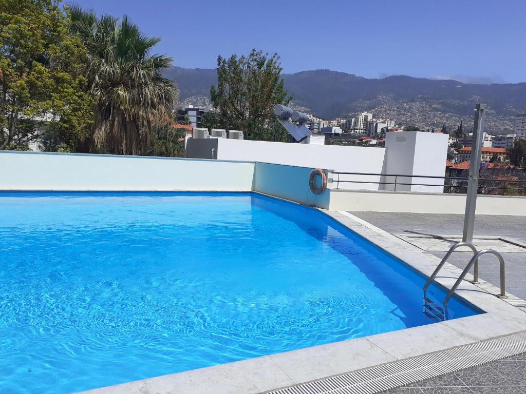 a large blue swimming pool on top of a building at Modern apartment in Funchal 60 m² with shared pool in Funchal