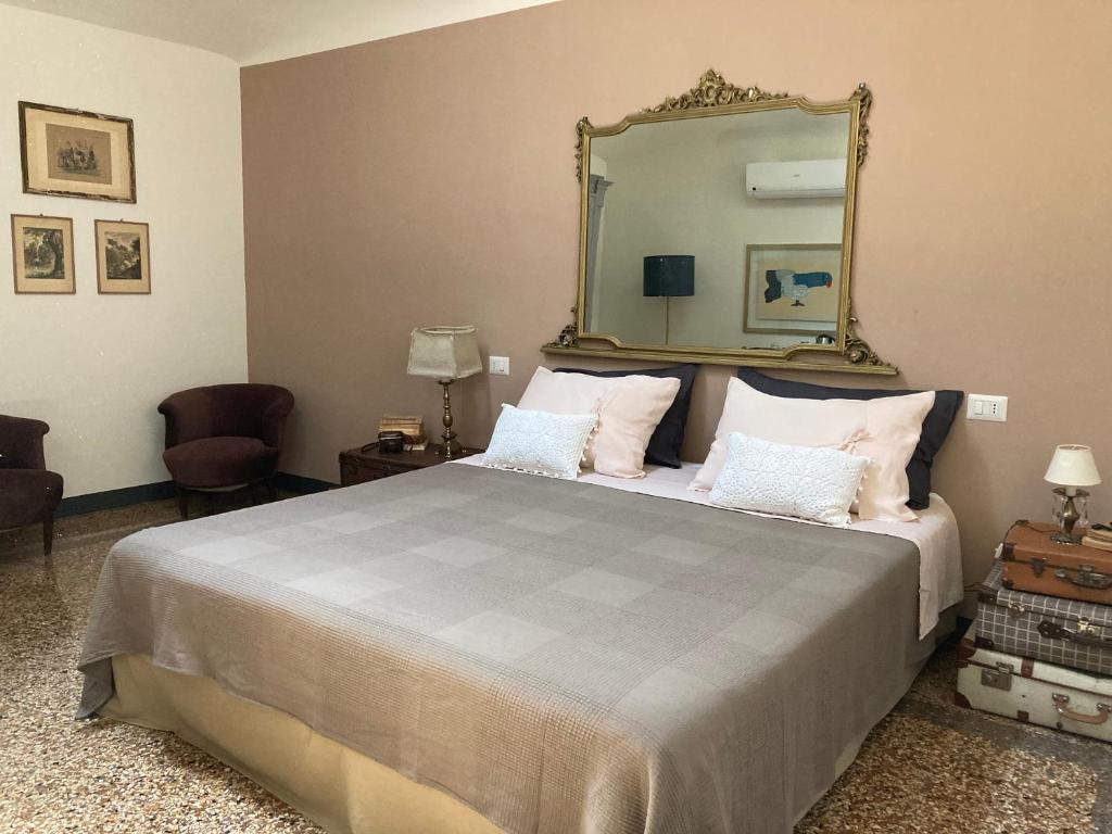 1 dormitorio con 1 cama grande y espejo grande en BLQ 01boutique B&B, en Bolonia
