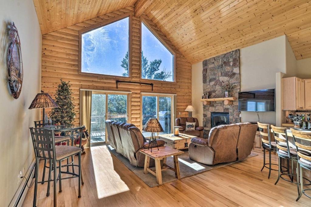 a living room with wooden walls and a large window at Spacious Fairplay Cabin with Mountain Views! in Fairplay