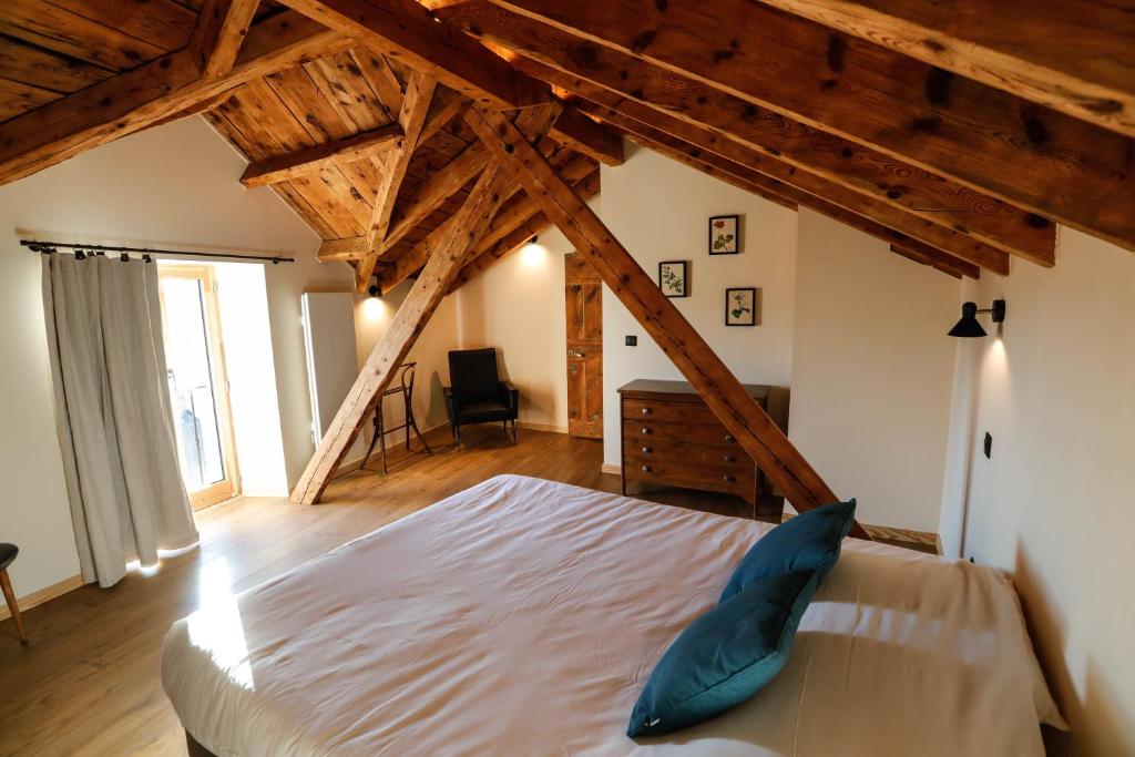 - une chambre avec un grand lit dans une pièce dotée de plafonds en bois dans l'établissement Domaine Agricole Cotzé / Casa rural, à Enveitg