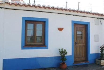 een blauw-wit huis met twee ramen en een deur bij Casa de Seixe in Odeceixe