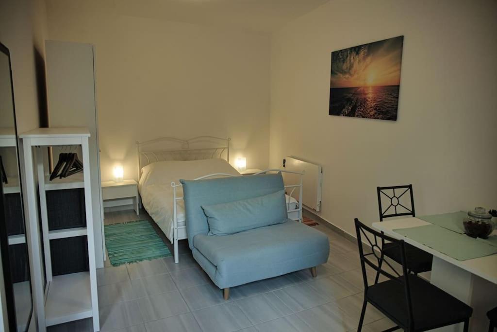 een slaapkamer met een bed, een stoel en een bureau bij Studio apartman Gajba in city center in Zagreb