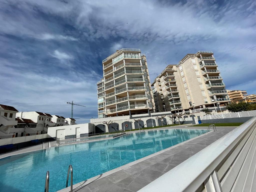 a large swimming pool with two tall buildings at Alpen1 Argenta/Caleta in Peniscola