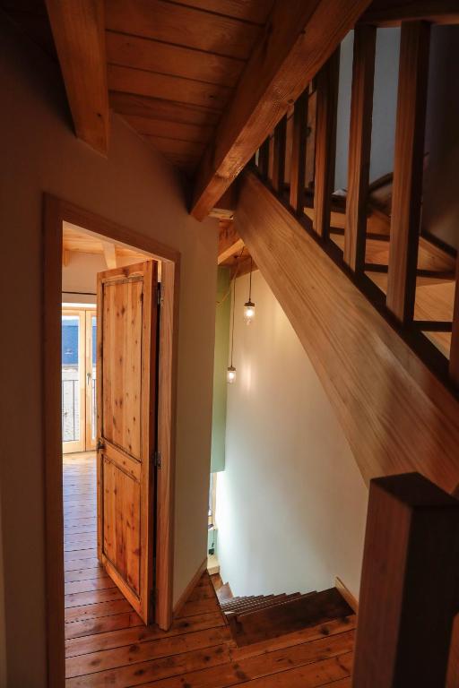 a hallway with a wooden staircase and a wooden door at Domaine Agricole Cotzé &#47; Casa rural in Enveitg