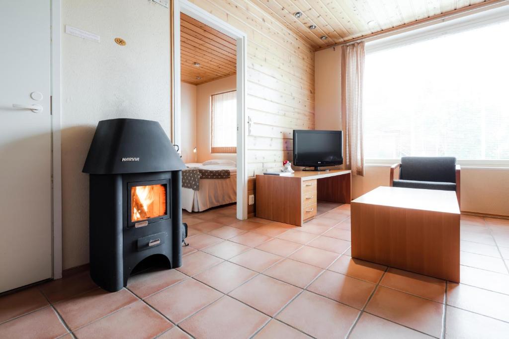 a living room with a stove in a room at Lapland Hotels Äkäshotelli in Äkäslompolo