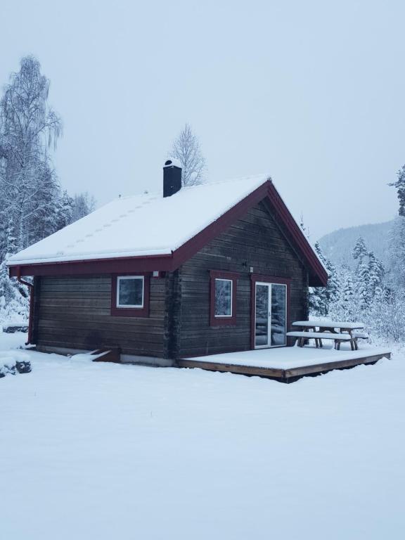 a cabin with a picnic table in the snow at Ammeråns Fiskecamp in Hammarstrand