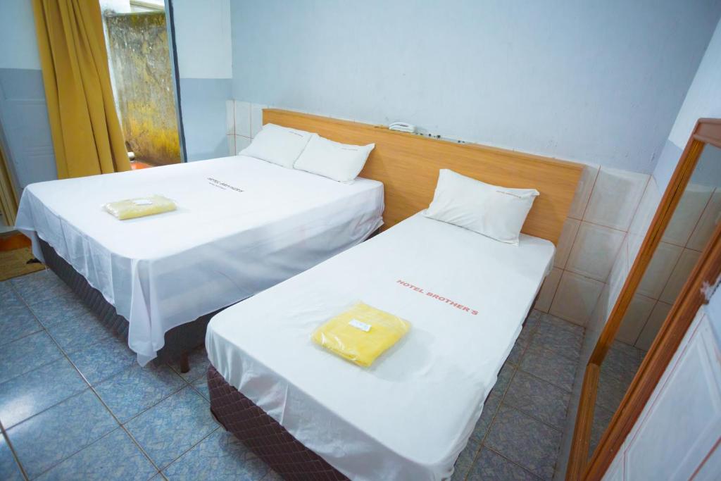 duas camas sentadas uma ao lado da outra num quarto em Hotel Brothers São Paulo - 3km do Hospital das Clínicas FMUSP, proximo a Universidades - By UP Hotel em São Paulo