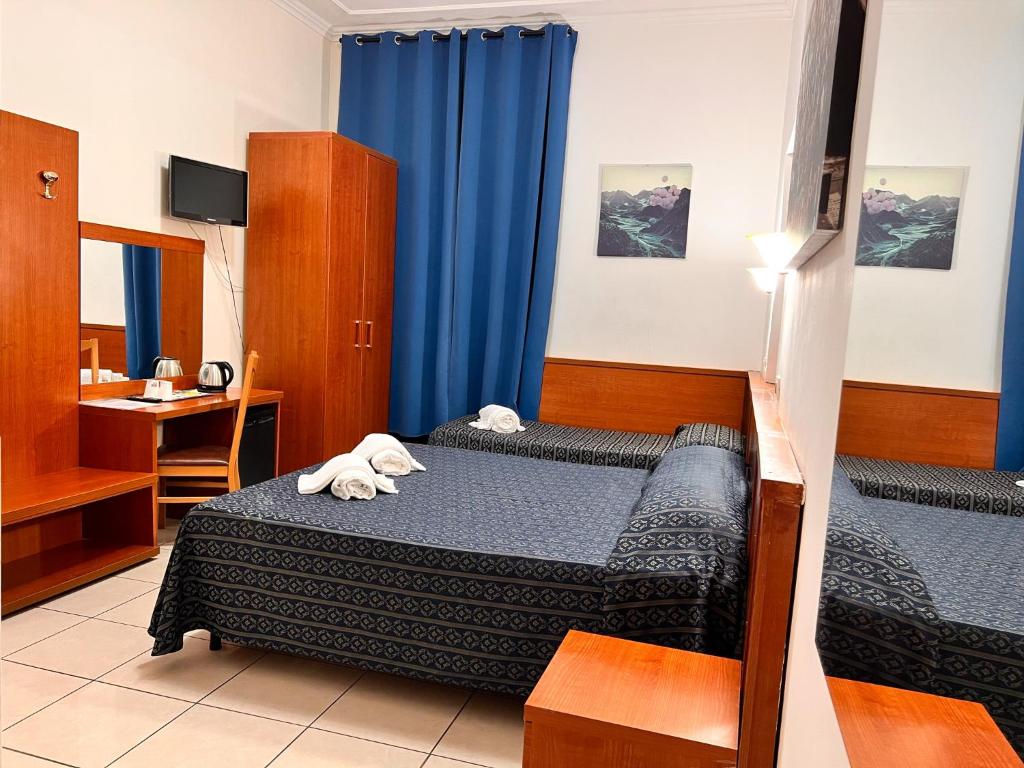 Pokój hotelowy z 2 łóżkami i biurkiem w obiekcie Alius and Freerome Hotel w Rzymie