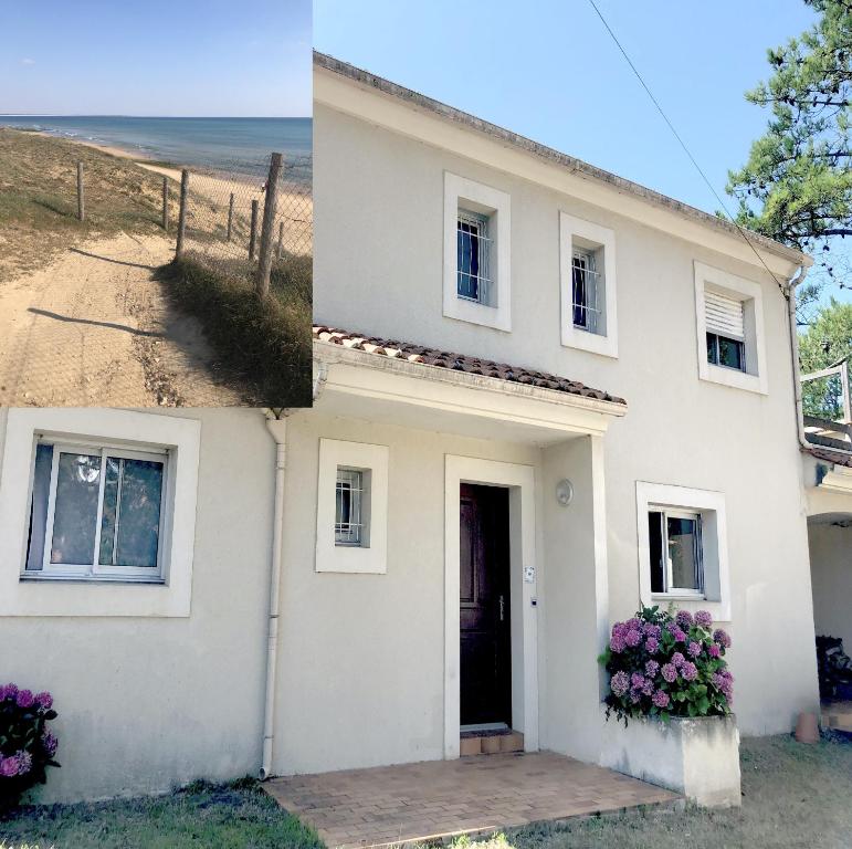 une maison blanche avec des fleurs devant elle dans l'établissement VILLA LES HORTENSIAS - proche de la plage, à Jard-sur-Mer