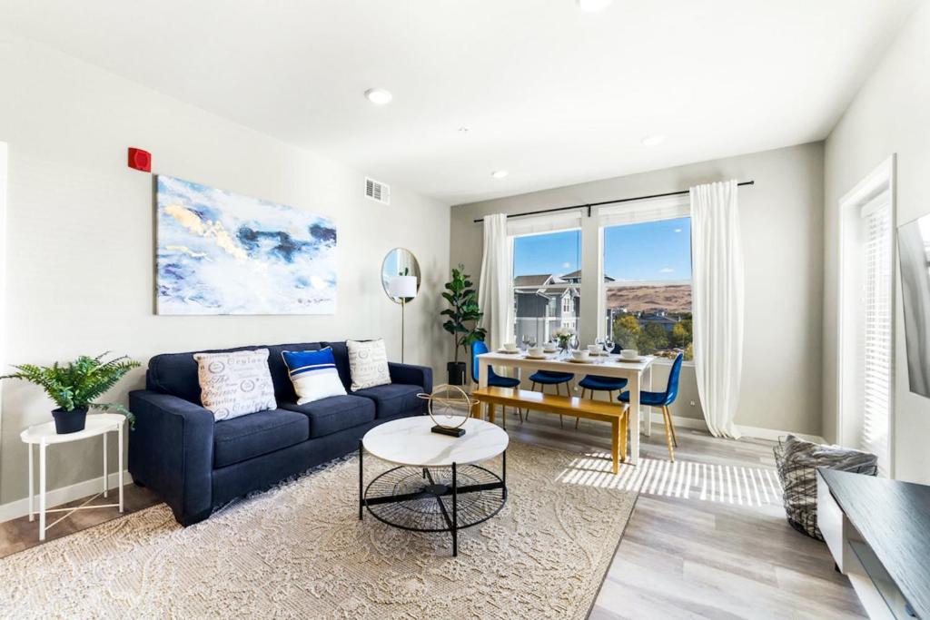 uma sala de estar com um sofá azul e uma mesa em Designer Apt with Jacuzzi, Pool & Mountain Views em Sparks
