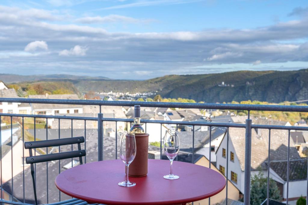 różowy stół z 2 kieliszkami do wina na balkonie w obiekcie Franze´s Haus - mit Rhein- & Burgenblick w mieście Boppard