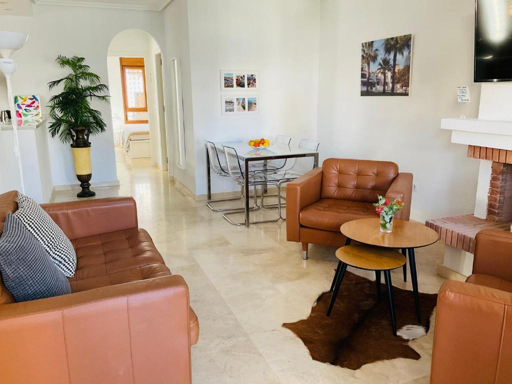 a living room with leather furniture and a table at Gound Floor Bungalow Jumilla III Playa Flamenca in Orihuela Costa