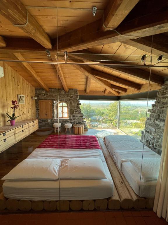 un grande letto in una stanza con una grande finestra di Mrizi i Zanave Agroturizëm a Lezhë (Alessio)