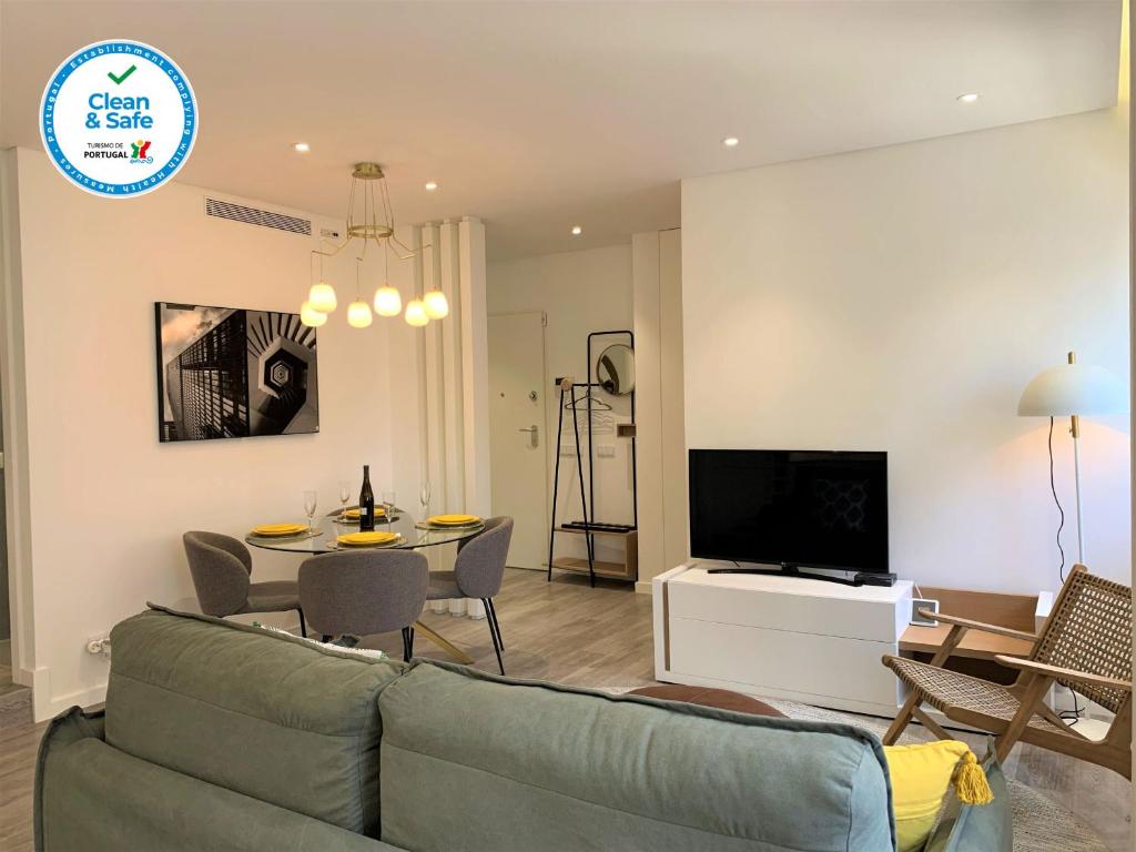 a living room with a couch and a table and a television at Cascais Downtown Premium Apartment 1 in Cascais