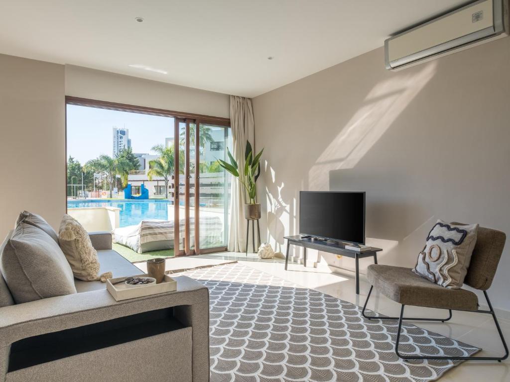 a living room with a couch and a tv at Sanders Aqua Park Resort - Precious 3-Bedroom Holiday Home With Shared Pool in Limassol