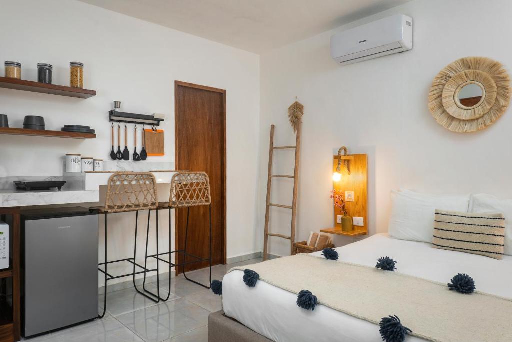a living room with two beds and a kitchen at Verandah Studios in Playa del Carmen