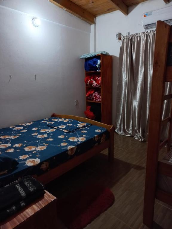1 dormitorio con 1 cama con edredón azul en Apart lo de Vivi en Puerto Iguazú