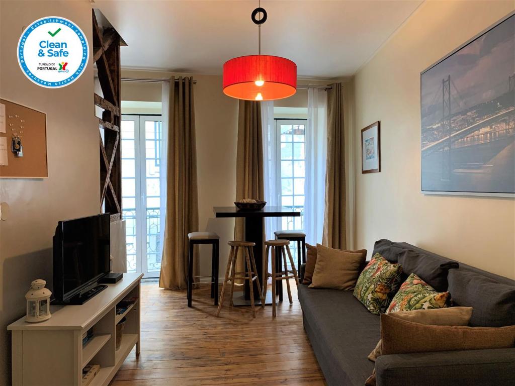 a living room with a couch and a tv at Bairro Alto apartments in Lisbon