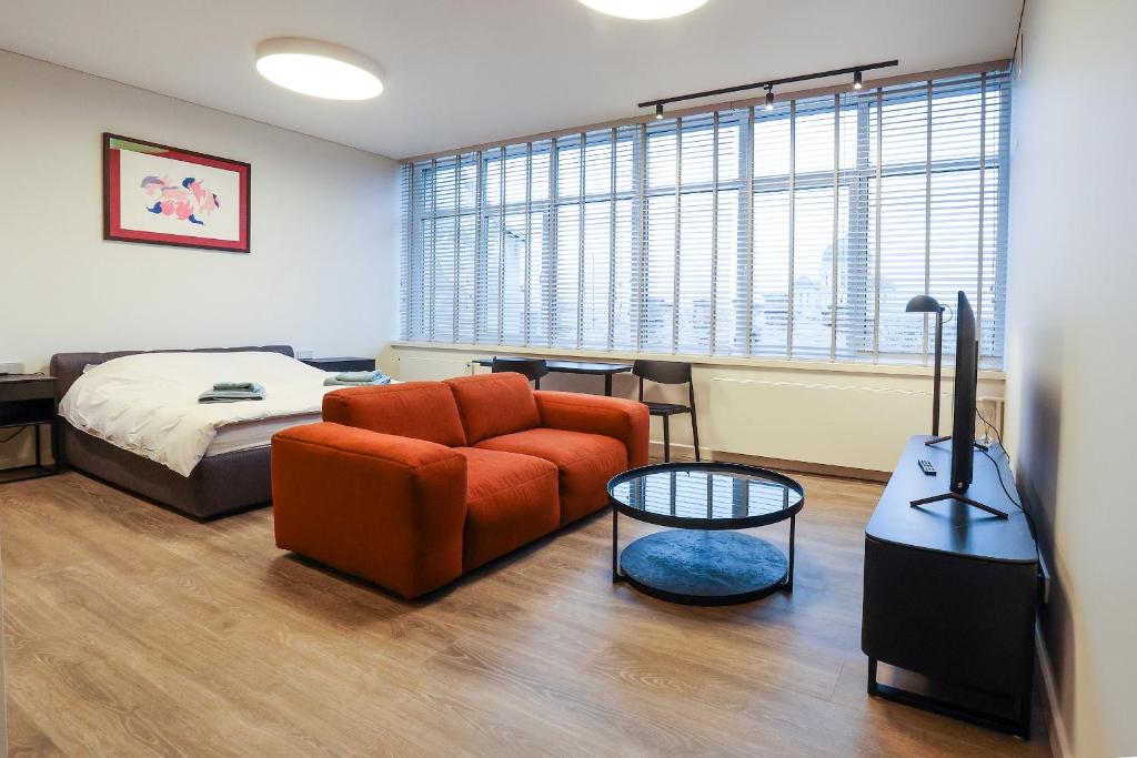 een slaapkamer met een bed, een bank en een tafel bij Studio 501 in Kaunas