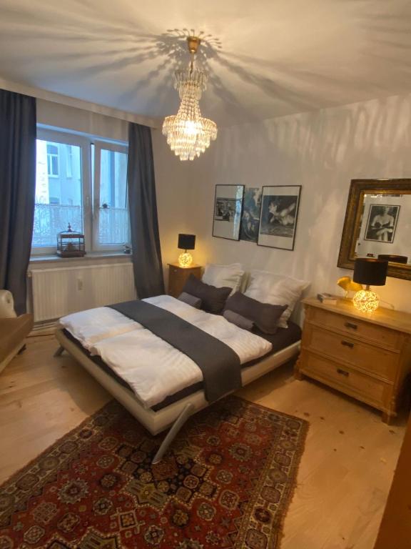 ein Schlafzimmer mit einem großen Bett und einem Kronleuchter in der Unterkunft Central City Privatapartment Relax-Inn, Netflix & Sky TV! in Hannover