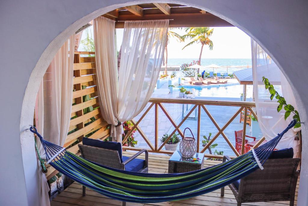 a hammock on a balcony with a view of the ocean at Ocean Point Resort & Spa Adults Only in Saint Johnʼs