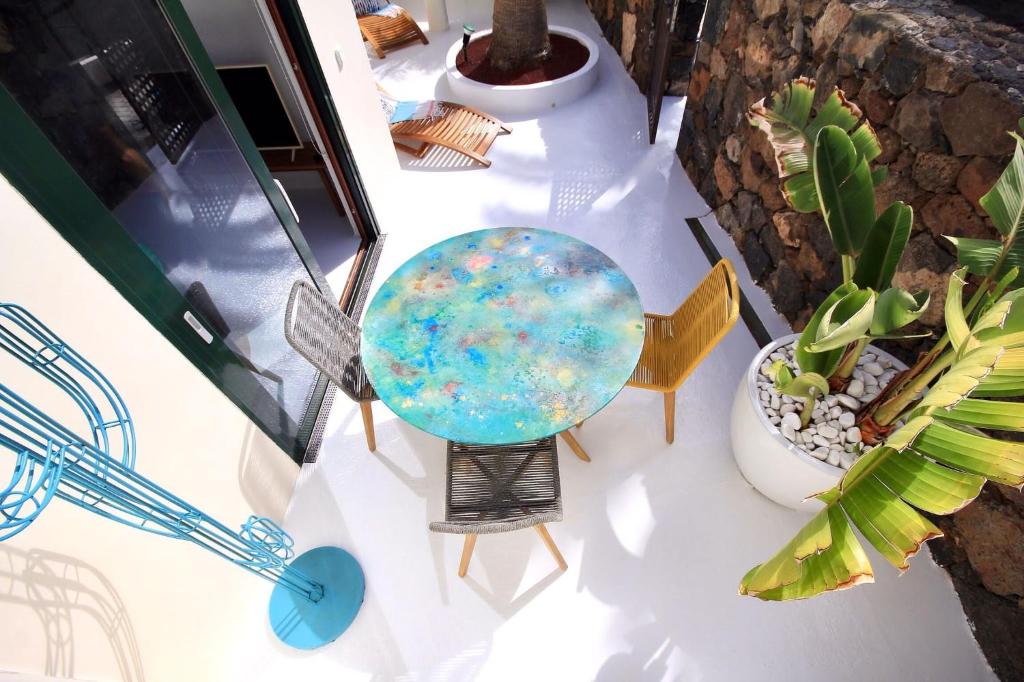 une table recouverte d'une table en verre avec une plante dans l'établissement Unique, Stylish & Calm Los Peces by the Sea, à Costa Teguise