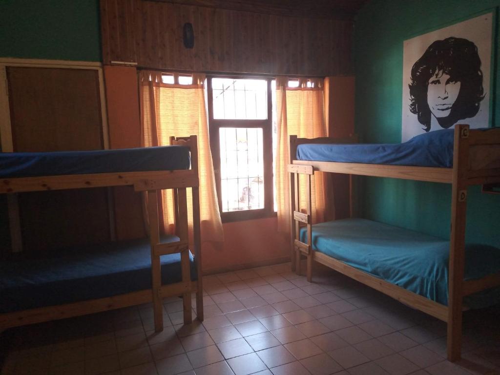 um quarto com 2 beliches e uma janela em Hostel "La Casita Naranja" em El Bolsón