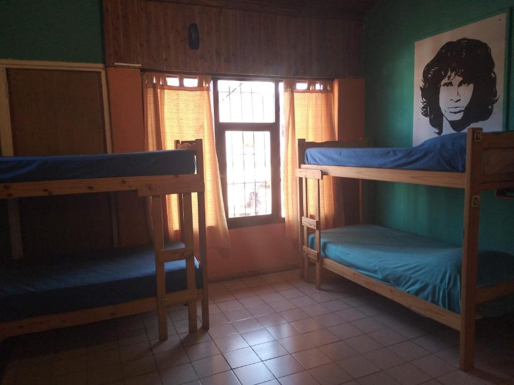 a room with two bunk beds and a window at Hostel "La Casita Naranja" in El Bolsón