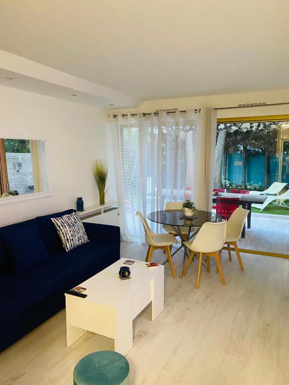 a living room with a blue couch and a table at 3 pièces terrasse, jardin in Cannes