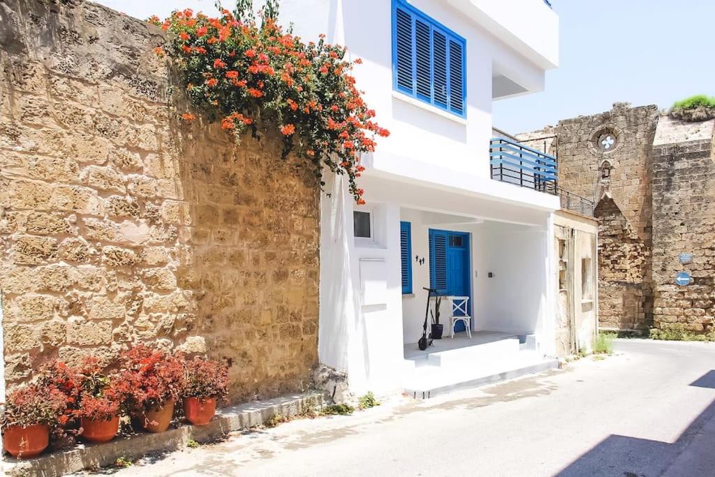 ein weißes Gebäude mit Blumen auf der Seite in der Unterkunft Blue Levant Guest House in Famagusta