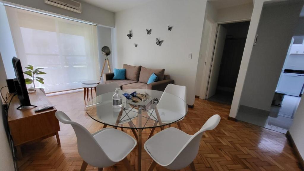 - un salon avec une table en verre et des chaises blanches dans l'établissement Mi corazon en San Telmo, à Buenos Aires