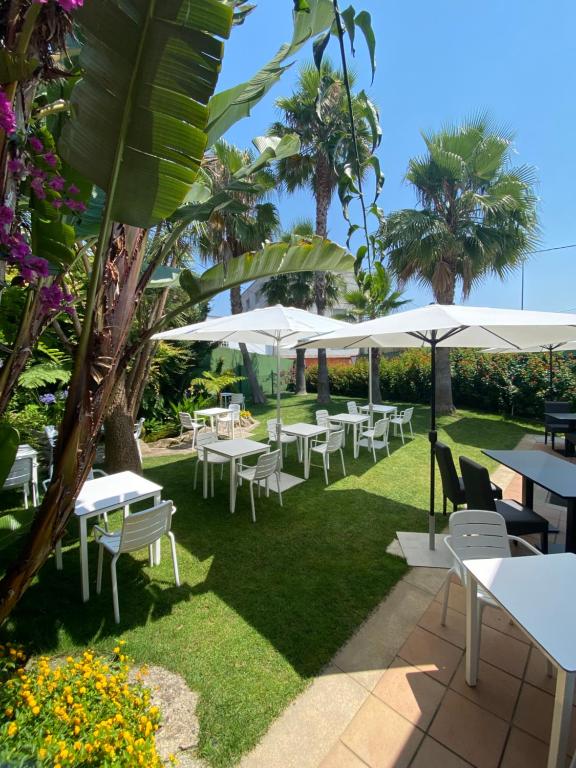 a row of tables and chairs with umbrellas at Hotel Combarro in Combarro