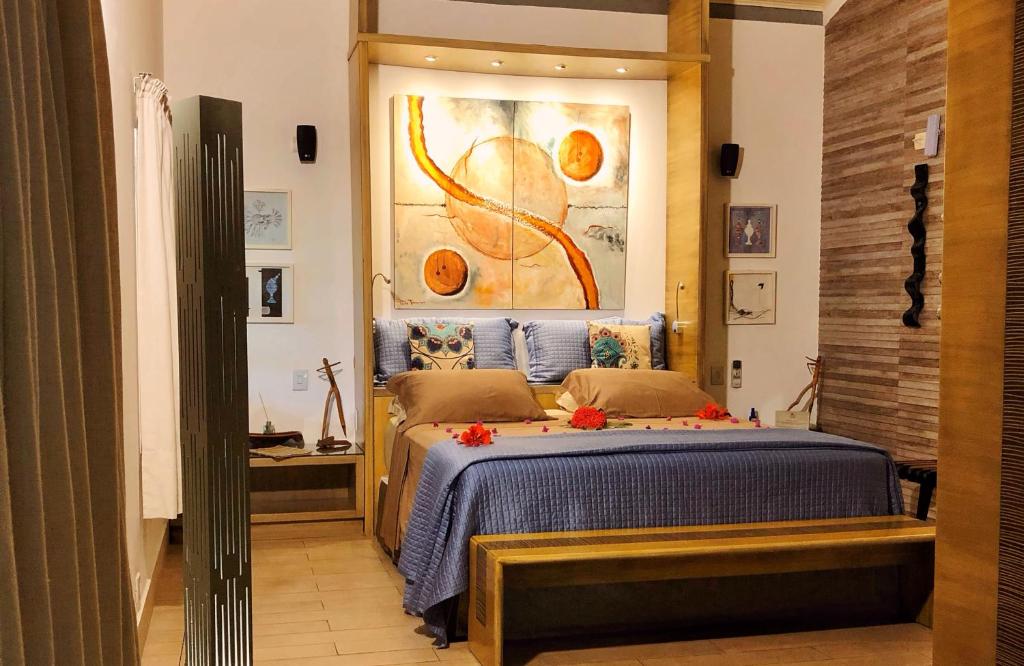 ein Schlafzimmer mit einem Bett und einem Wandgemälde in der Unterkunft CASA ACAYU in São Miguel dos Milagres